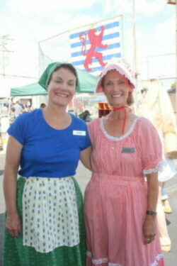 Two women wearing bonnets and a top and skirt.